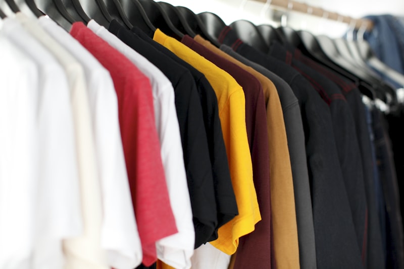 A person browsing a rail of clothes and examining a garment in a shop.