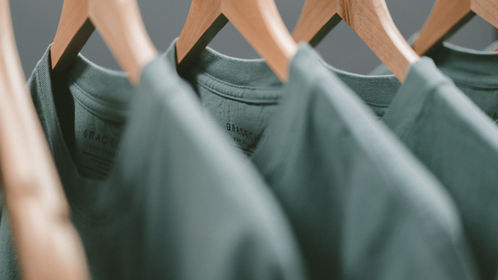 A tidy clothing rail with plain shirts and jackets in neutral tones.