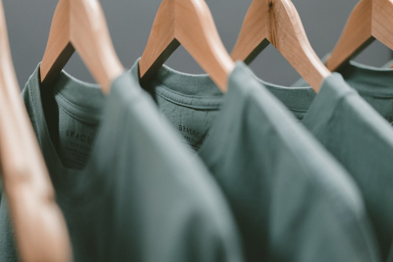 A tidy clothing rail with plain shirts and jackets in neutral tones.
