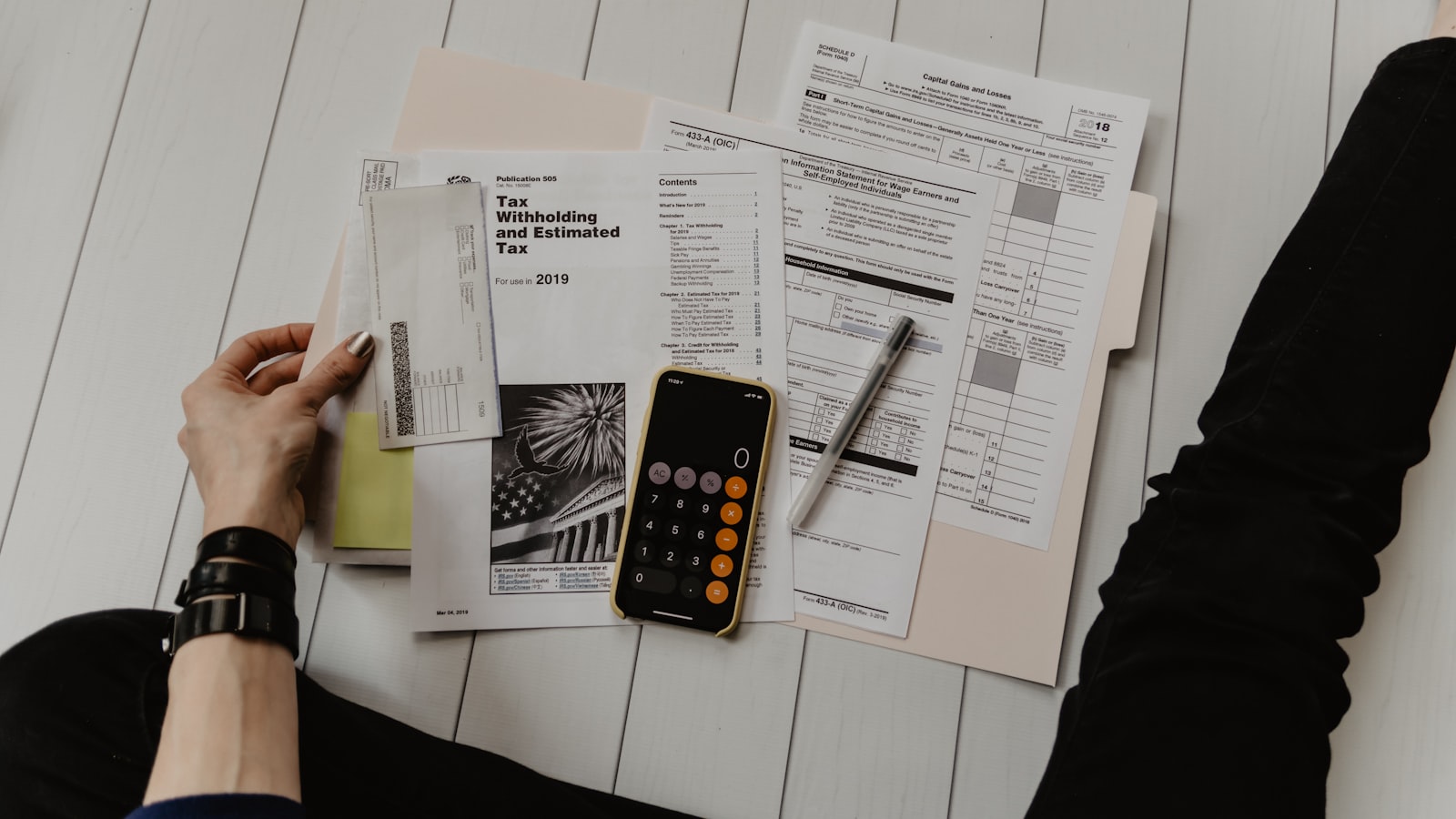 A notebook, calculator, and pen on a desk for planning a budget.