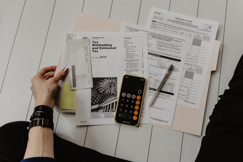 A notebook, calculator, and pen on a desk for planning a budget.