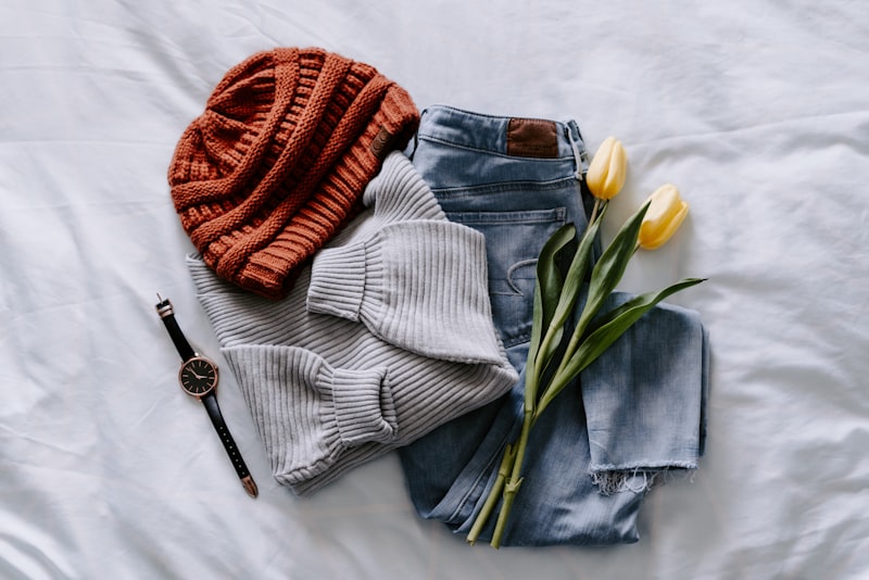A neat stack of folded clothes and knitwear on a shelf.