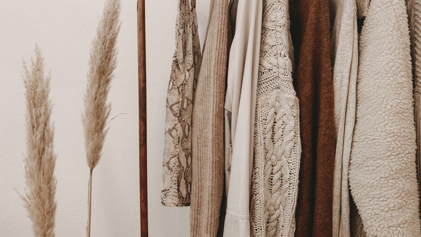 Folded clothing in coordinated neutral and soft accent colors arranged together.