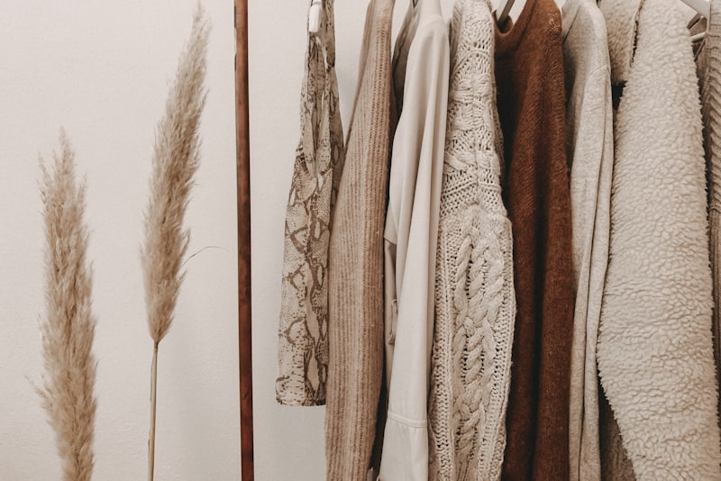 Folded clothing in coordinated neutral and soft accent colors arranged together.